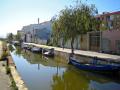 Canal with small boats of the saltwater lagoon in the Valencian pedanía of the palm grove.